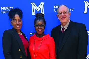 School of Nursing Dean Kenya Beard, nursing executive Launette Woolforde and School of Business Dean Lloyd Gibson standing in front of a Mercy University step and repeat banner.