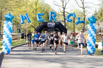 Racer pass the finish line at Mercy University's Conquer the Trail 7.5K