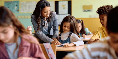 Teacher in Classroom with Young Student