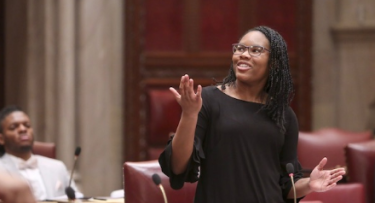 Woman in black dress in NY Legislature