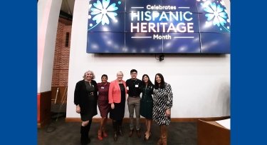 Eva Fernandez, Sonia Martinez, Susan Parish, Ronny Delgado, Adriana Rivera and Cosette Guiterrez stand in front of the Hispanic Heritage Celebration sign