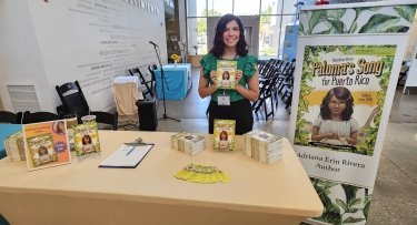 Mercy University employee Adriana Erin Rivera poses with her book Paloma’s Song for Puerto Rico: A Diary from 1898 