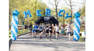 Racer pass the finish line at Mercy University's Conquer the Trail 7.5K