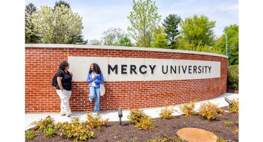 Students in front of Mercy University entrance at the Westchester Campus