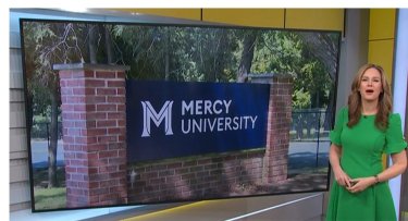 News 12 anchor with Mercy University sign in the background