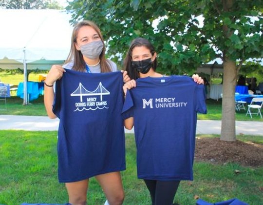 students holding campus t shirts