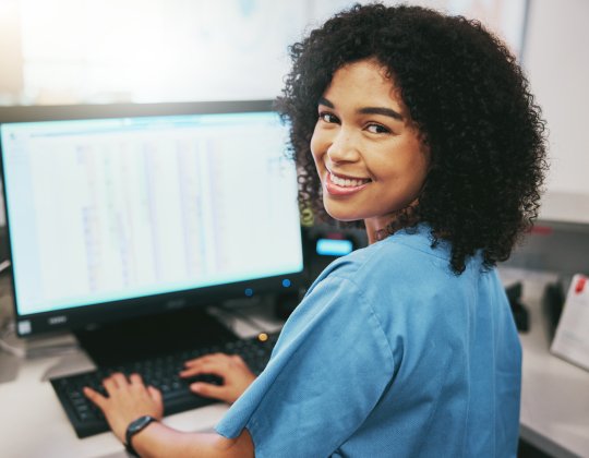 Woman smiling by a computer