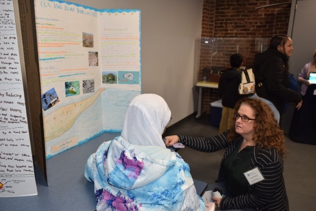 Dr. Meghan Marrero, professor of secondary science education and co-director of the Center for STEM at Mercy University, who co-leads the program, speaks to one of the students at the symposium